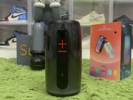A portable speaker beside its packaging